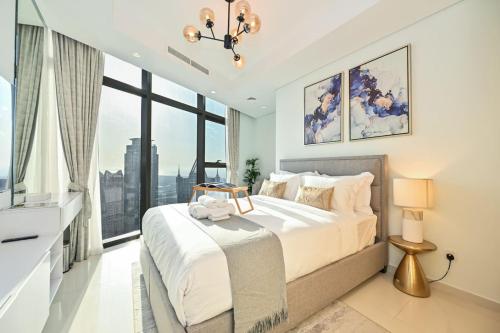 a bedroom with a large bed and a large window at New Luxury SeaView 2Bed - Spectacular Rooftop Infinity Pool, Bar & Burj Views! in Dubai