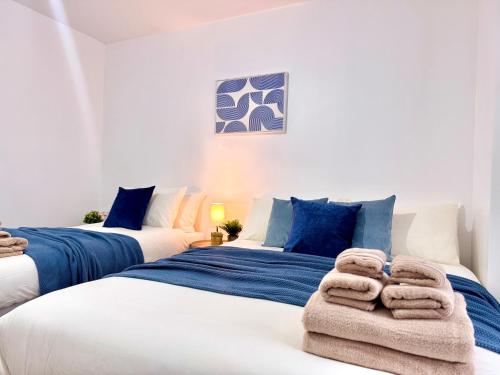 two beds in a room with towels on them at Comfy Studio 30min to Central London in London