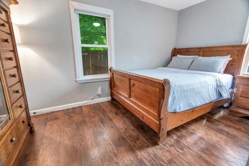 a bedroom with a bed with a dresser and a window at Cheerful 2-Bedroom with convenient Expressway access in Springfield