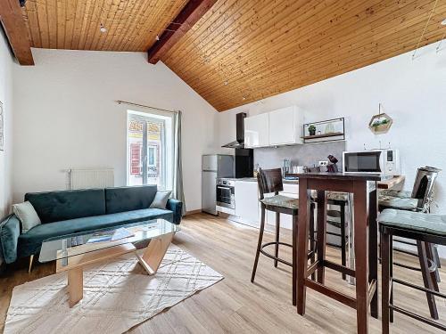 un salon avec un canapé bleu et une cuisine dans l'établissement F3 refait à neuf en centre ville Liberation, à Clermont-Ferrand