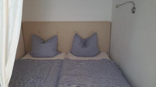 a bed with two pillows on top of it at Seetempel 19 - direkt am Strand ,Hunde willkommen in Scharbeutz