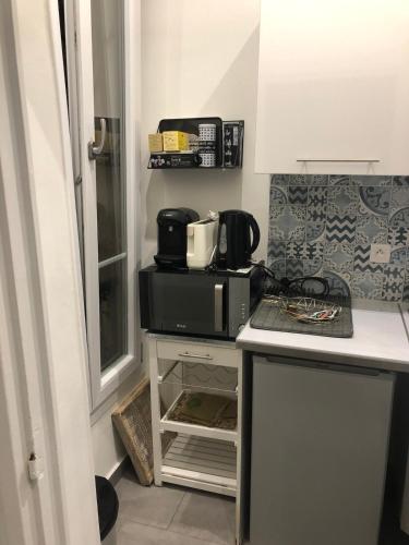 une cuisine avec un four micro-ondes au-dessus d'un comptoir dans l'établissement Lovely Cosy Studio Nice, à Nice