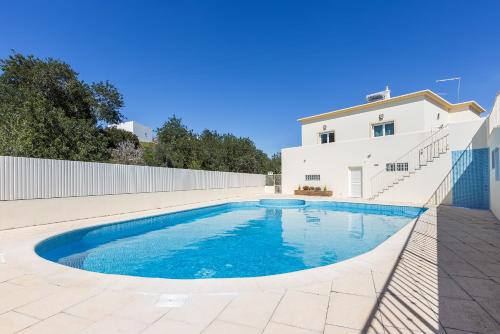 a swimming pool in front of a white house at D_Loft Sea and Golf in Albufeira