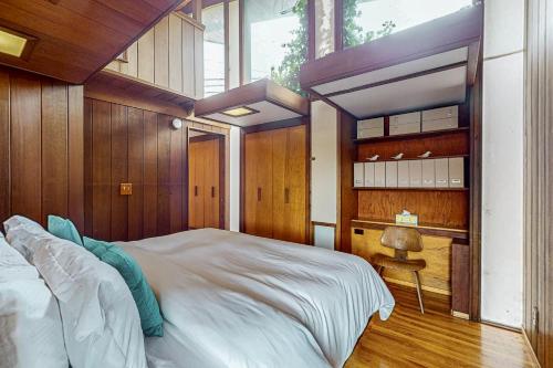 a bedroom with a large bed with wooden walls at Elk Mid-Century - Guest House in Elk