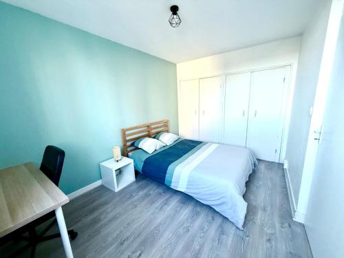 une chambre avec un lit, une table et un bureau dans l'établissement Appartement au pied du métro., à Toulouse