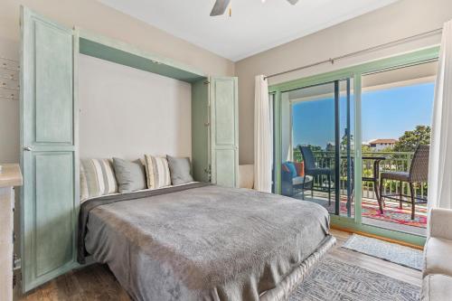 a bedroom with a large bed and a balcony at Inn at Seacrest 309- Somewhere in the Sun in Inlet Beach