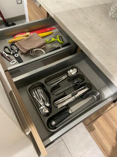 un tiroir dans un comptoir avec des ustensiles de cuisine dans l'établissement Au Pays Des Cigognes, à Colmar