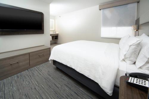 a hotel room with a bed and a flat screen tv at Holiday Inn Express - Canyon by IHG in Canyon