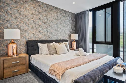 メルボルンにあるChic Townhouse in South Yarraのベッドルーム1室(大型ベッド1台、ランプ2つ付)