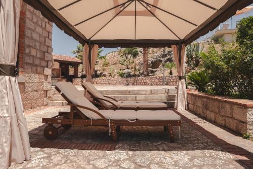 a pair of lounge chairs and an umbrella on a patio at Villa Caterina in Acquedolci