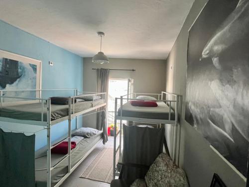 Zimmer mit 3 Etagenbetten und einem Gemälde in der Unterkunft The Island Hostel & Café in Lagos