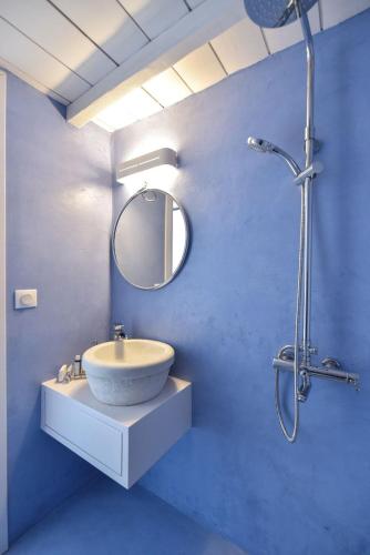 a bathroom with a sink and a shower with a mirror at Lobster House Tinos in Arnados