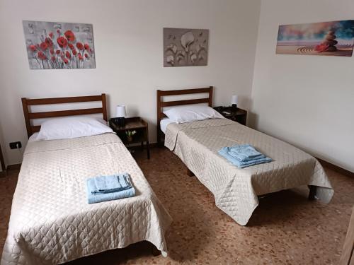 two beds sitting next to each other in a room at Casa Fiume in Mantova
