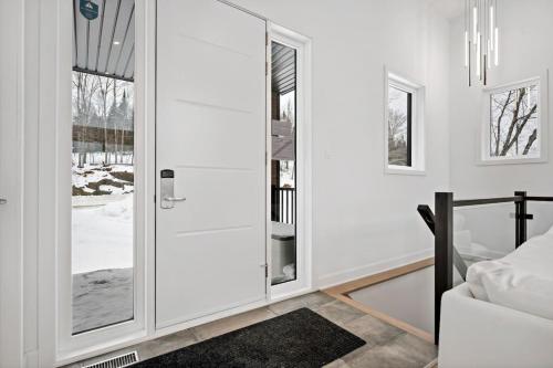 a glass door in a room with a bedroom at Luxury 5BR Chalet with Sauna, Hot Tub and Game Room in La Conception