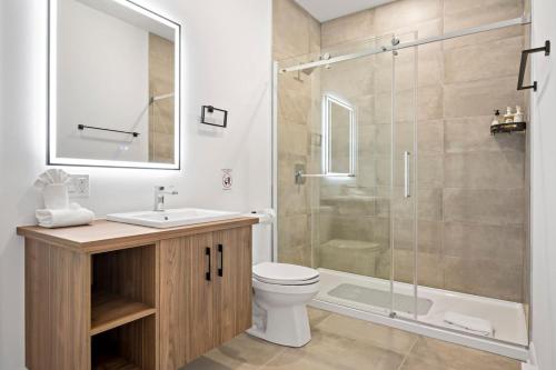 a bathroom with a shower and a toilet and a sink at Luxury 5BR Chalet with Sauna, Hot Tub and Game Room in La Conception
