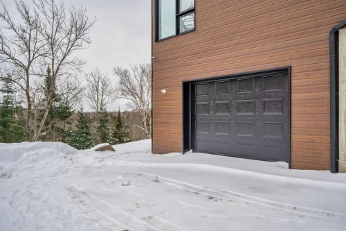 a garage door in the snow in front of a house at Luxury 5BR Chalet with Sauna, Hot Tub and Game Room in La Conception
