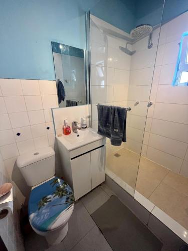 a bathroom with a toilet and a sink and a shower at The Island Hostel & Café in Lagos
