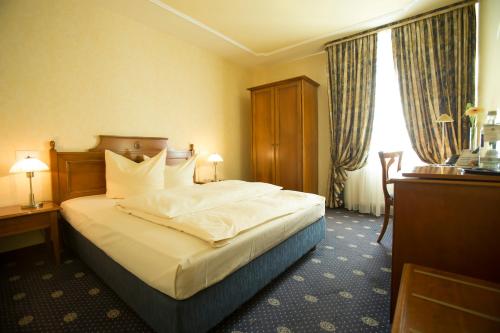 a hotel room with a large bed and a window at Parkhotel Idar-Oberstein in Idar-Oberstein
