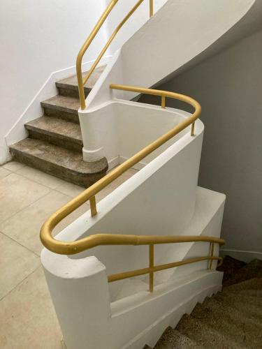 a staircase with a gold handrail on the stairs at Savanna Sky in Fort-de-France