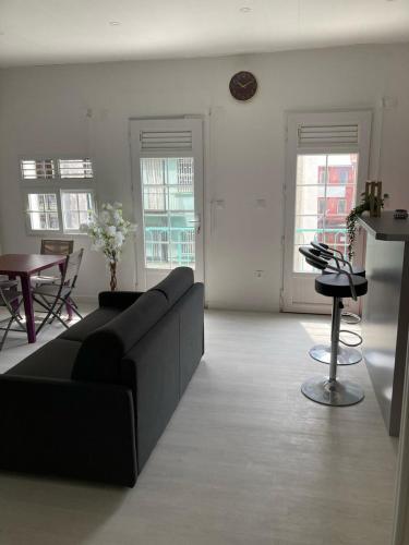 a living room with a black couch and a table at Savanna Sky in Fort-de-France