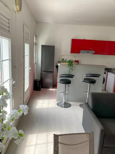 a kitchen and living room with a counter and stools at Savanna Sky in Fort-de-France