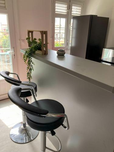 a kitchen with a counter and a black chair at Savanna Sky in Fort-de-France