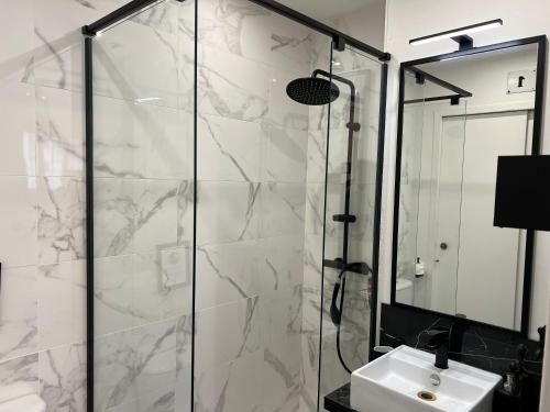 une salle de bain avec une douche en verre et un lavabo dans l'établissement Studio industriel cosy à 1 min du Vieux-Port Calme & Tout équipé, à Marseille