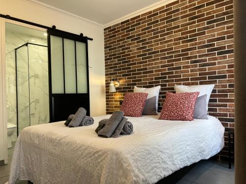 une chambre avec un grand lit avec un mur de briques dans l'établissement Studio industriel cosy à 1 min du Vieux-Port Calme & Tout équipé, à Marseille