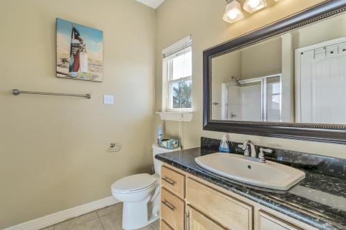 a bathroom with a sink and a toilet and a mirror at Parrot Head Home in Bolivar Peninsula