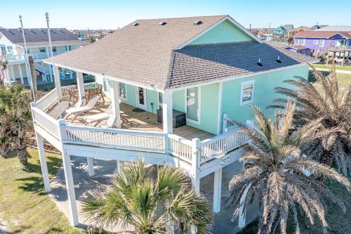an aerial view of a blue house with a deck at Parrot Head Home in Bolivar Peninsula