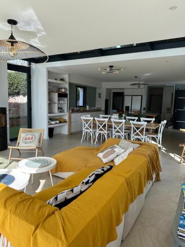 - un grand lit jaune dans un salon avec une cuisine dans l'établissement Villa Larmor-baden, à Larmor-Baden