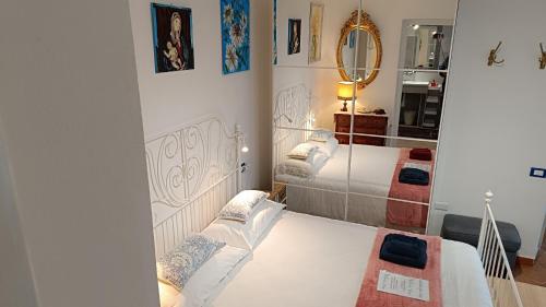 Un dormitorio con dos camas y un espejo. en Tipica villetta ligure indipendente arredata con gusto e comfort 1 camera da letto parcheggio interno zona Lerici Monti San Lorenzo, en Lerici