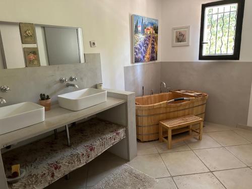une salle de bain avec deux lavabos et une baignoire dans l'établissement Belle villa contemporaine avec piscine, à Laudun-l'Ardoise
