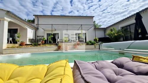 une piscine dans l'arrière-cour d'une maison dans l'établissement Belle villa contemporaine avec piscine, à Laudun-l'Ardoise