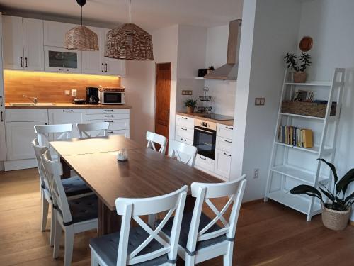 a kitchen with a wooden table and white cabinets at Chalupa Na Polní in Jemnice
