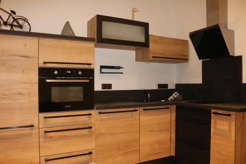 La cuisine est équipée d'armoires en bois et d'un four noir. dans l'établissement apartment center Sélestat Le Melimi, à Sélestat