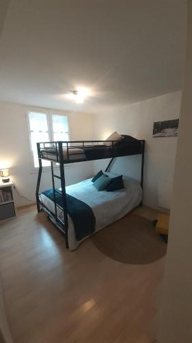 "L'Ostal Daouan" Grand appartement 8 personnes proche La Mongie et Payolle في كامبان: غرفة نوم مع سرير بطابقين في غرفة