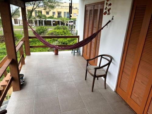 a hammock on the porch of a house at Casa Amarela com Vista para o Mar in Arroio do Sal
