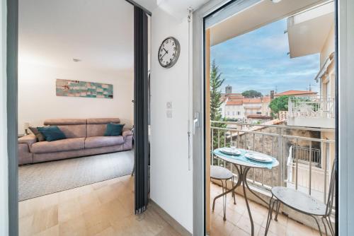 Cette chambre dispose d'un balcon avec un canapé et un réveil. dans l'établissement Studio au calme dans le quartier du Suquet - Proche Croisette et centre-ville, à Cannes