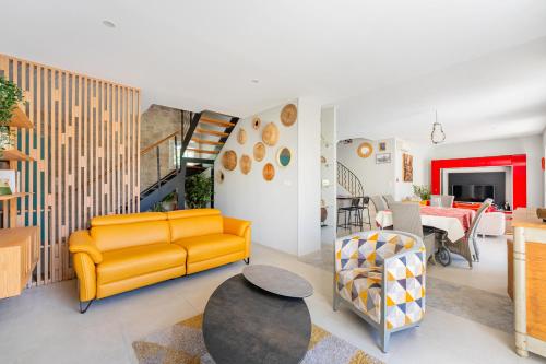 un salon avec un canapé jaune et une table dans l'établissement Moun Oustau, à Avignon