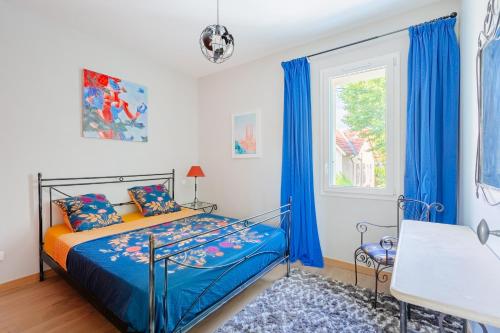 a bedroom with a bed and a window with blue curtains at Moun Oustau in Avignon