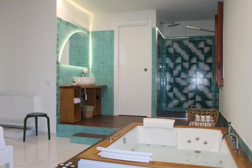 a bathroom with a tub and a green tiled wall at Il Melograno in Costa d'Amalfi - romantic experience in Vietri sul Mare