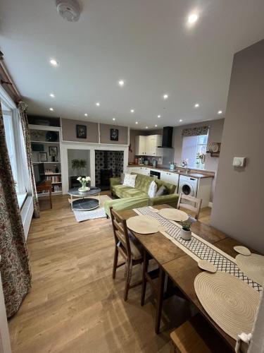 a kitchen and living room with a table and chairs at Charlton Old Farm Guesthouse in Greenhaugh