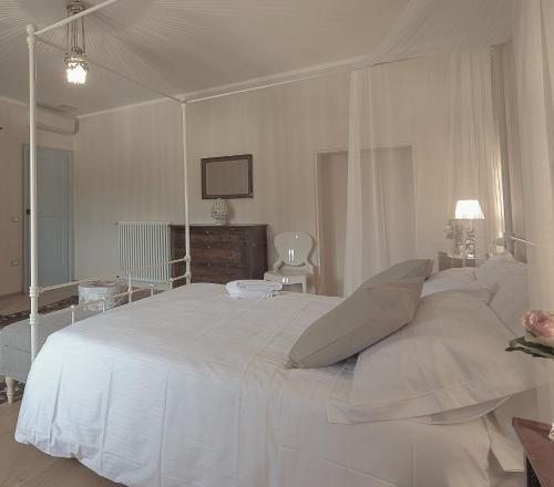 a white bedroom with a large white bed with pillows at B&B Palazzo Mattei in Novafeltria