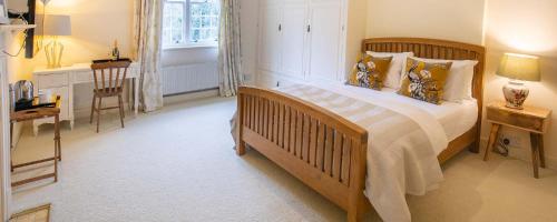 a bedroom with a large bed and a table and a chair at Little Massingham Manor in Little Massingham