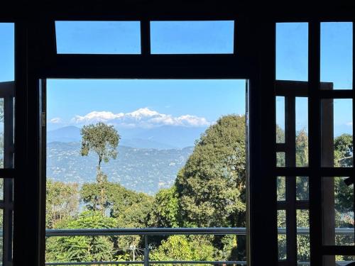 Una ventana con vista a la montaña. en Tamang Valley Homestay, en Kalimpong