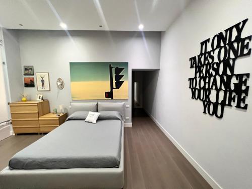 a bedroom with a bed and a painting on the wall at RaRoom Luxury R-Aparthotel in Torre del Greco