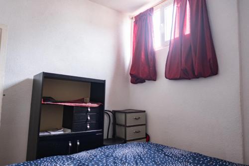 a bedroom with a bed and a dresser and a window at Gera's house in Bitola