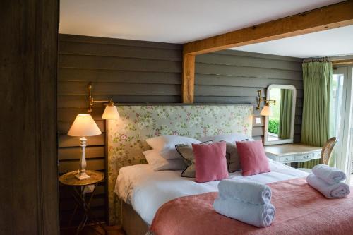 a bedroom with a large white bed with pink pillows at Retreat East in Ipswich