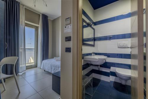 a blue and white bathroom with a bed and a sink at Hotel Belvedere in Torre dell'Orso